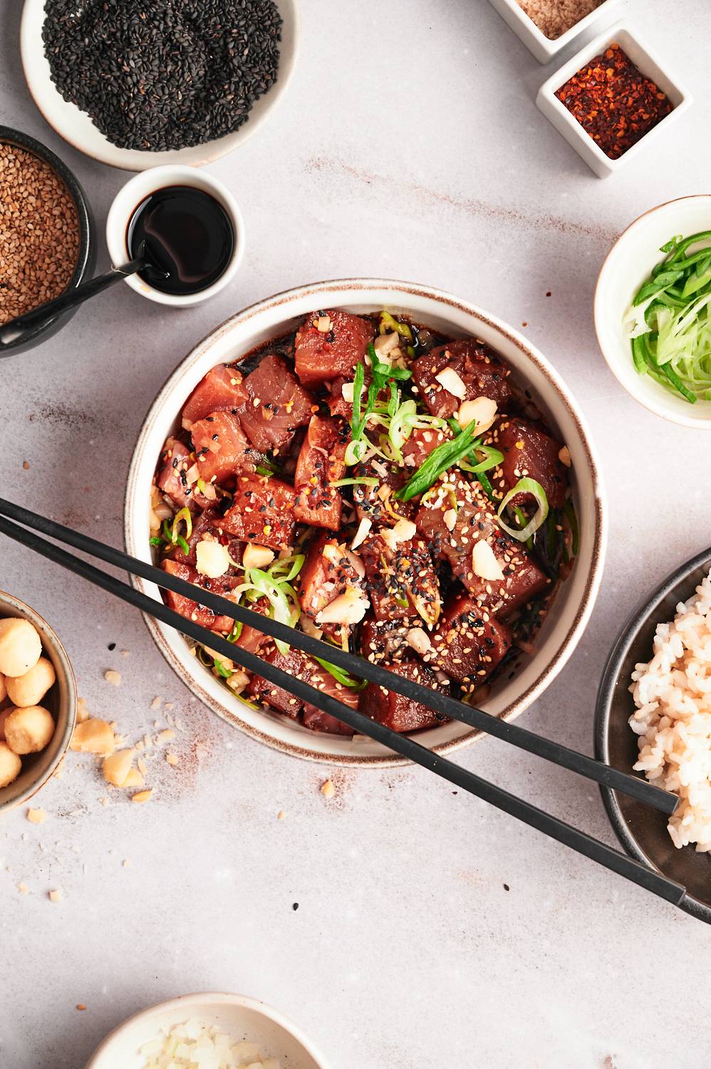 Raw tuna poke with ahi tuna chunks, green onions, macadamia nuts, sesame seeds, and soy sauce.