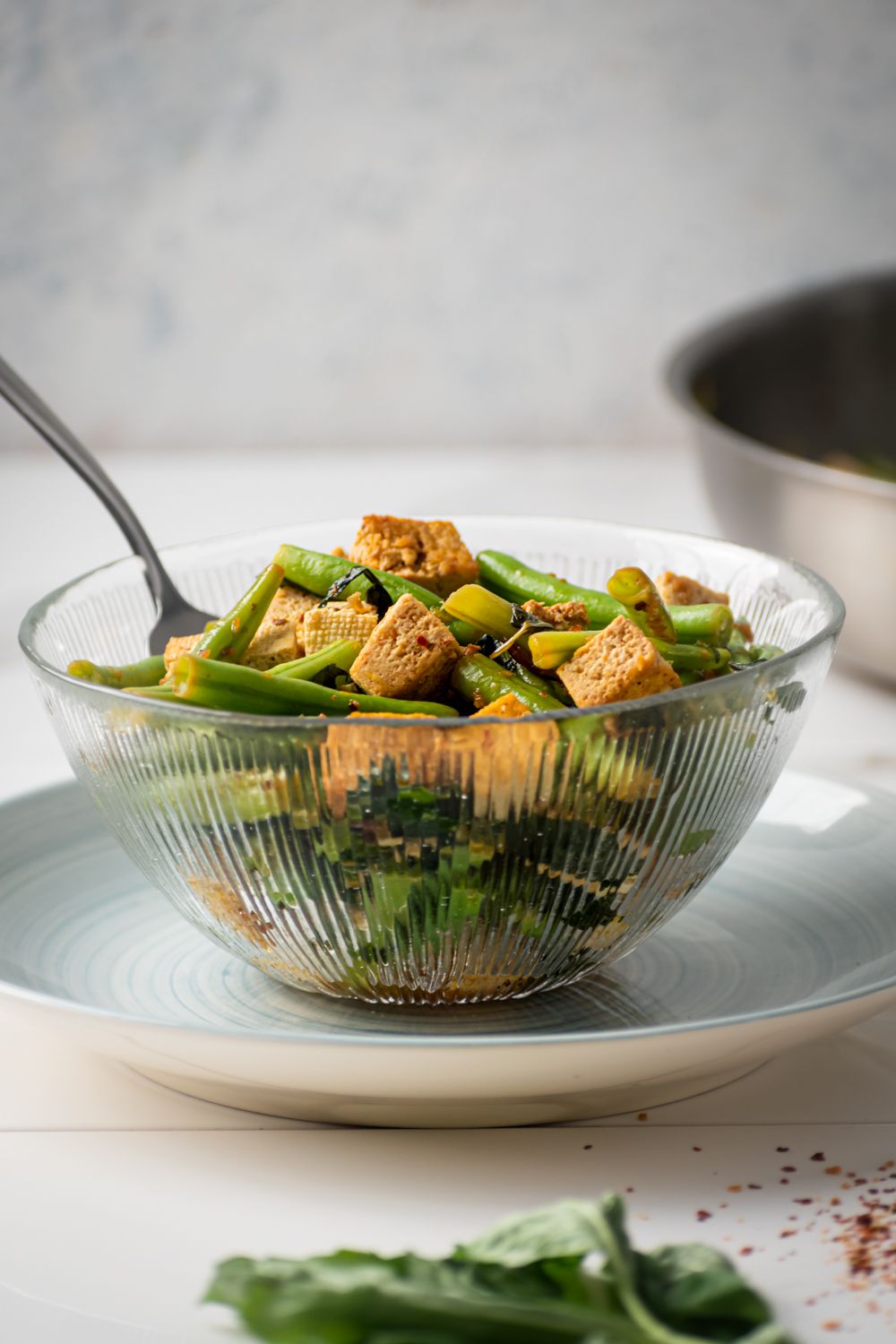 Bowl with basil stir fried tofu and green beans.