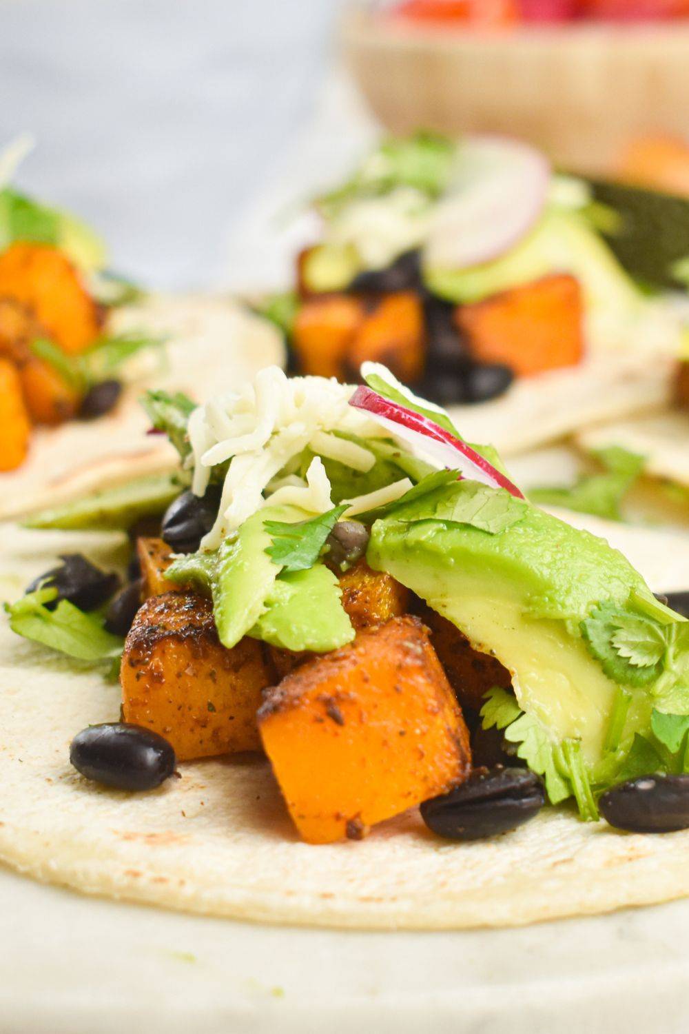Roasted butternut squash tacos with avocado, cilantro, radish, and cheese. 