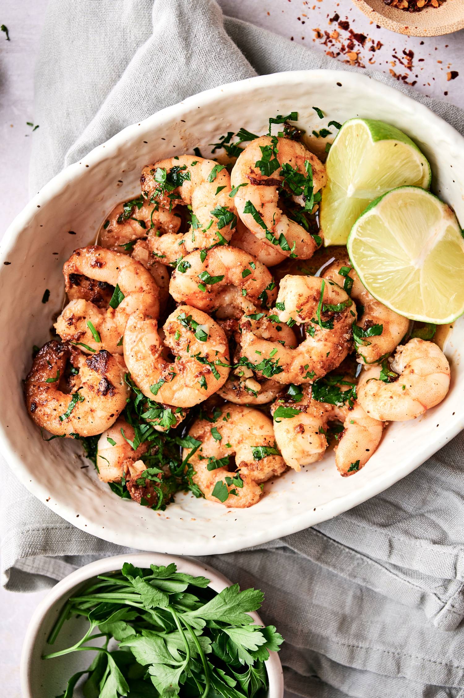 Mexican garlic shrimp with chile peppers, tender shrimp, parsley, and lime wedges.