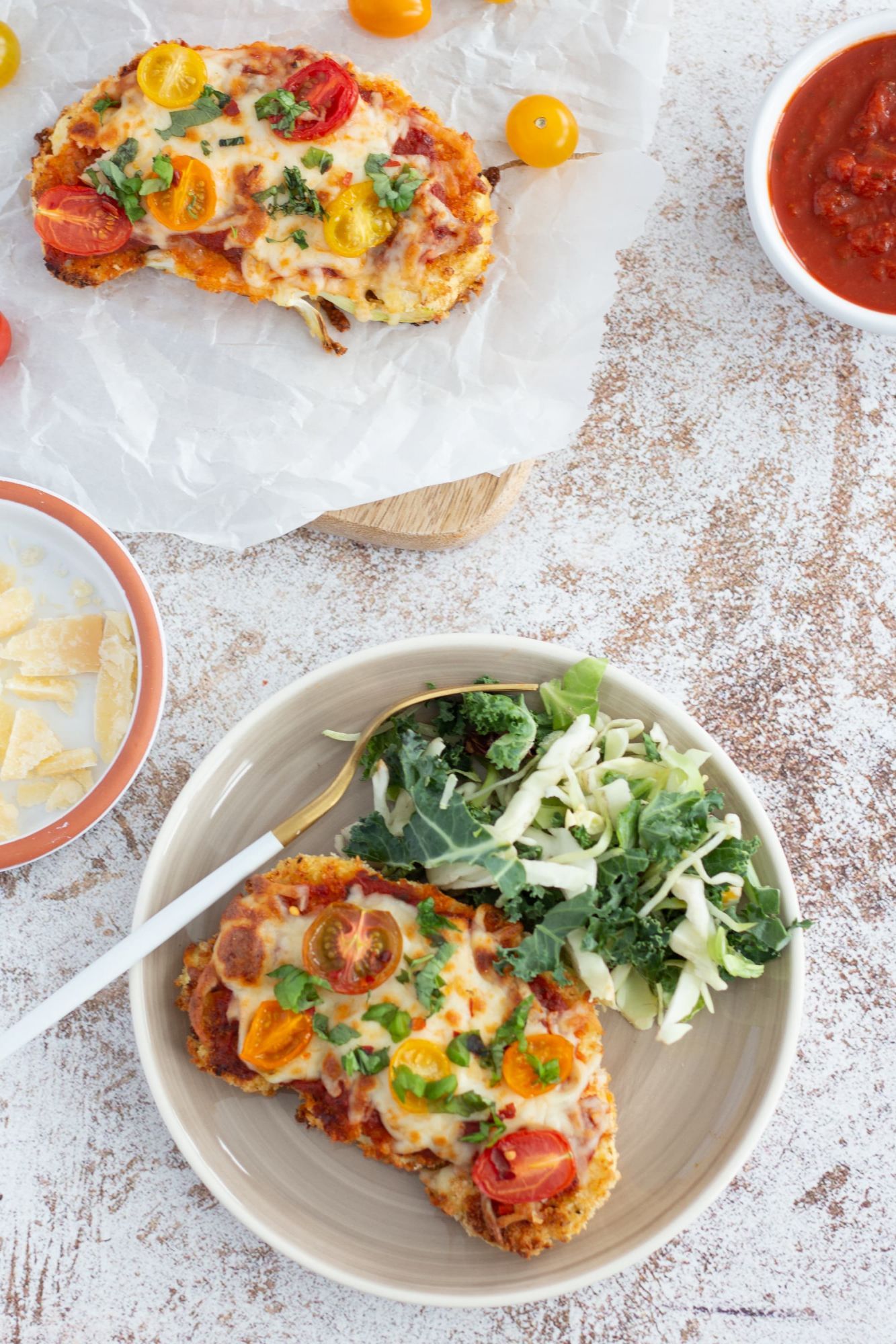 Cauliflower steak parmesan with marinara sauce and melted mozzarella served with salad.