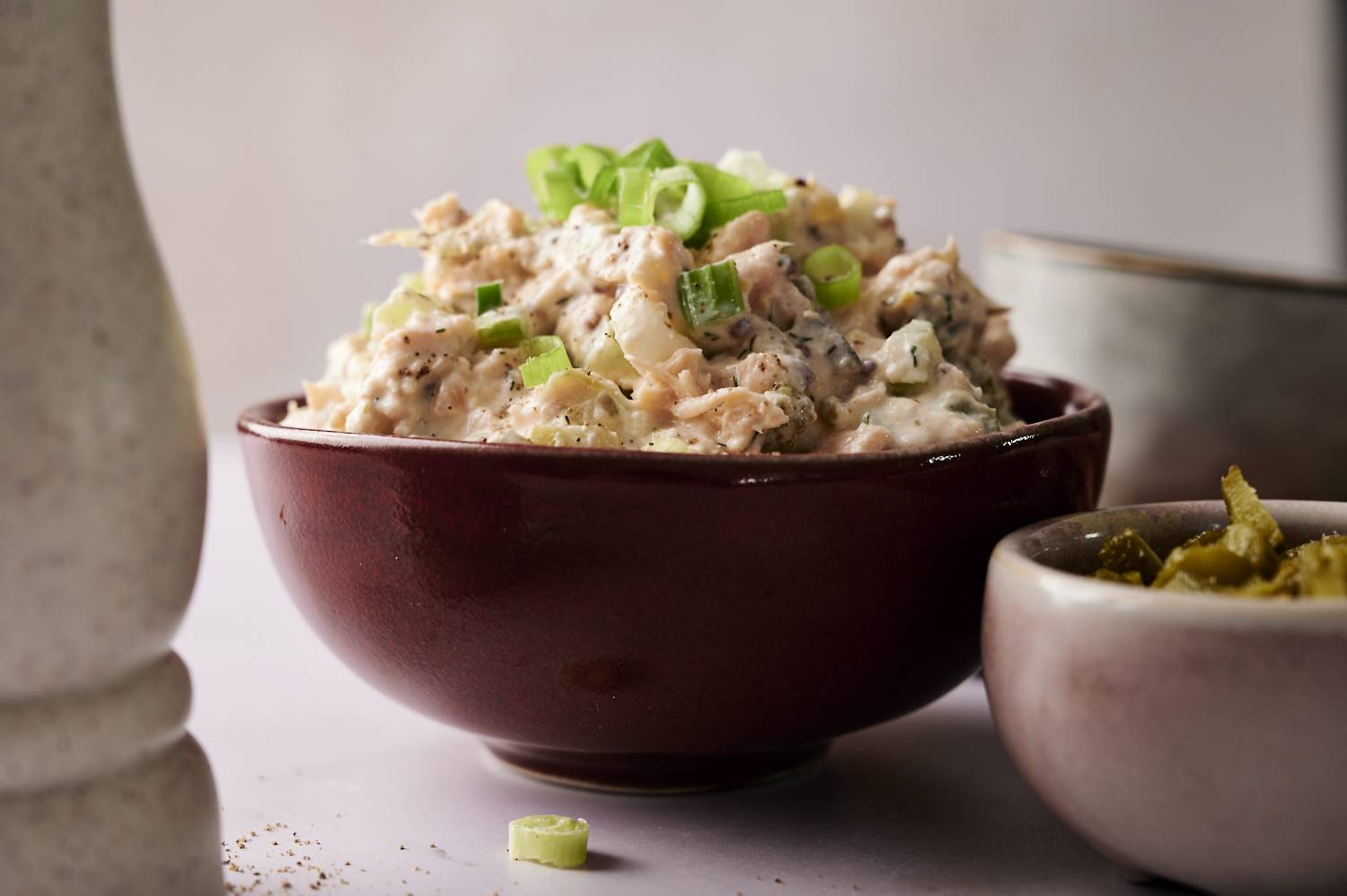 A close-up, eye-level shot of a bowl of dill pickle salmon salad.