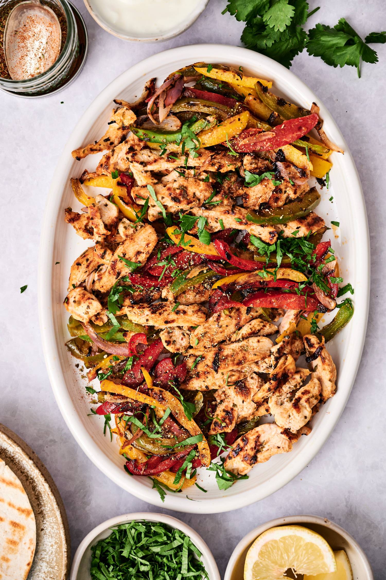 Platter of grilled chicken fajitas with lightly charred chicken, red onions, and bell peppers.