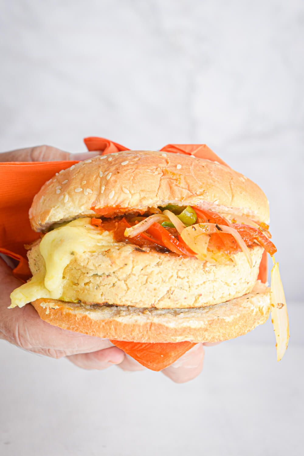 White bean veggie burgers made pizza style with tomato sauce, cheese, basil, peppers, and onions.