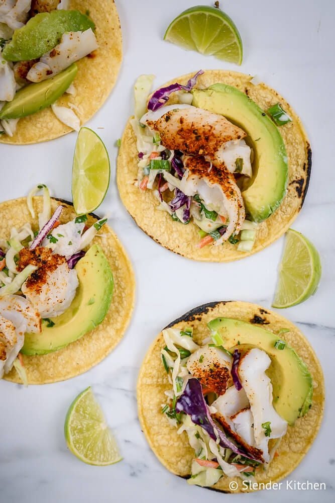 Ancho fish tacos with lime slaw and avocado on corn tortillas.