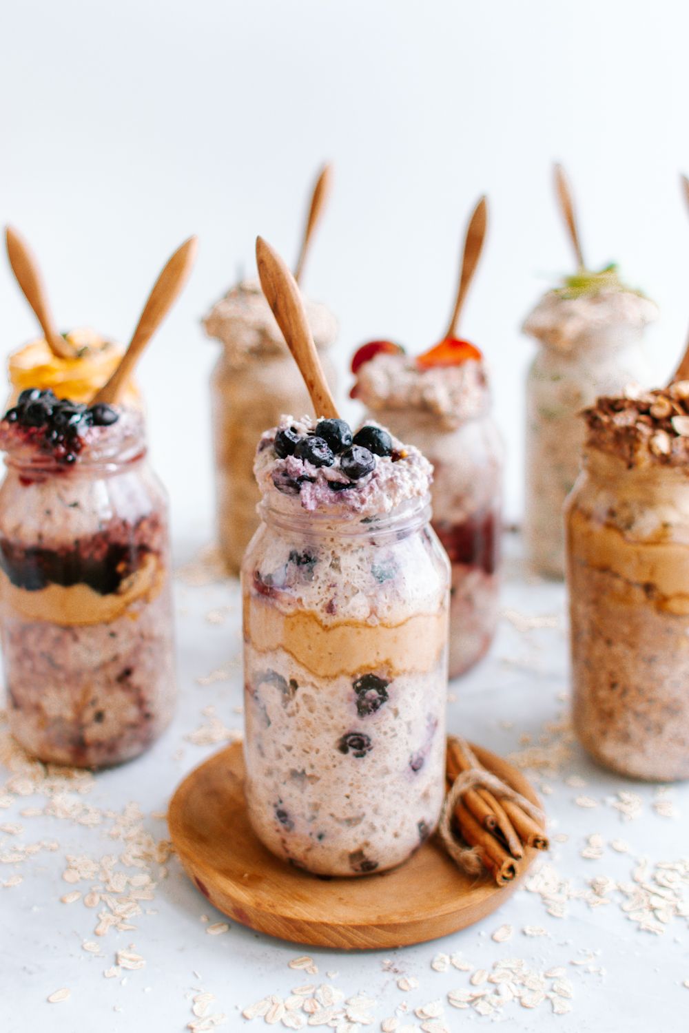 Blueberry almond overnight oats in a glass jar with other overnight oatmeal jars in the background.