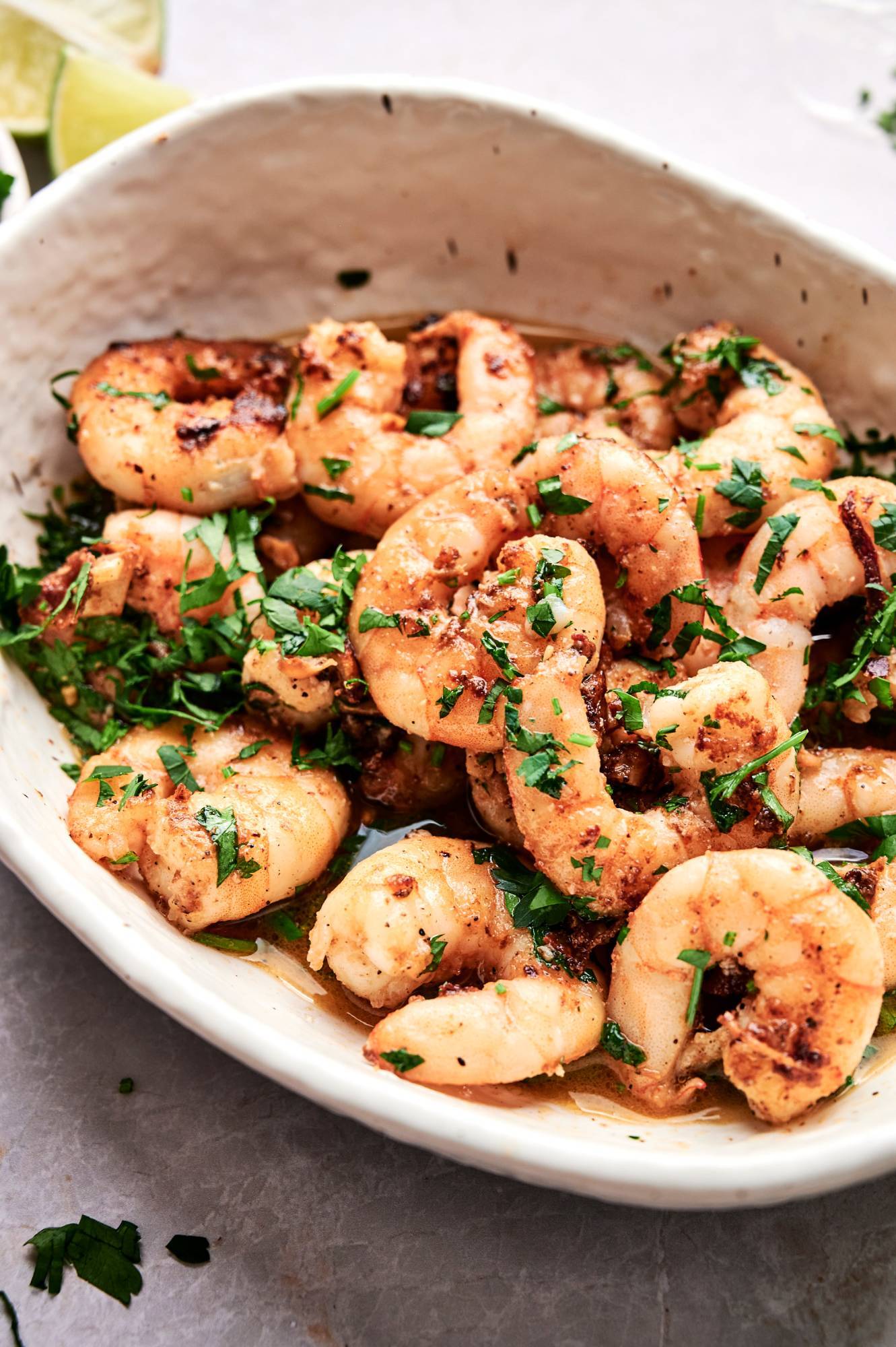 Sauteed garlic shrimp in a bowl with minced garlic, guajillo peppers, parsley, and lime juice.