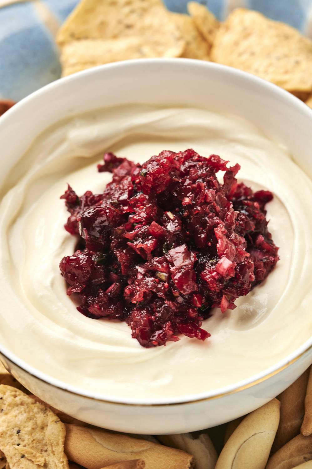 Cranberry jalapeño cream cheese dip in a bowl surrounded by chips.