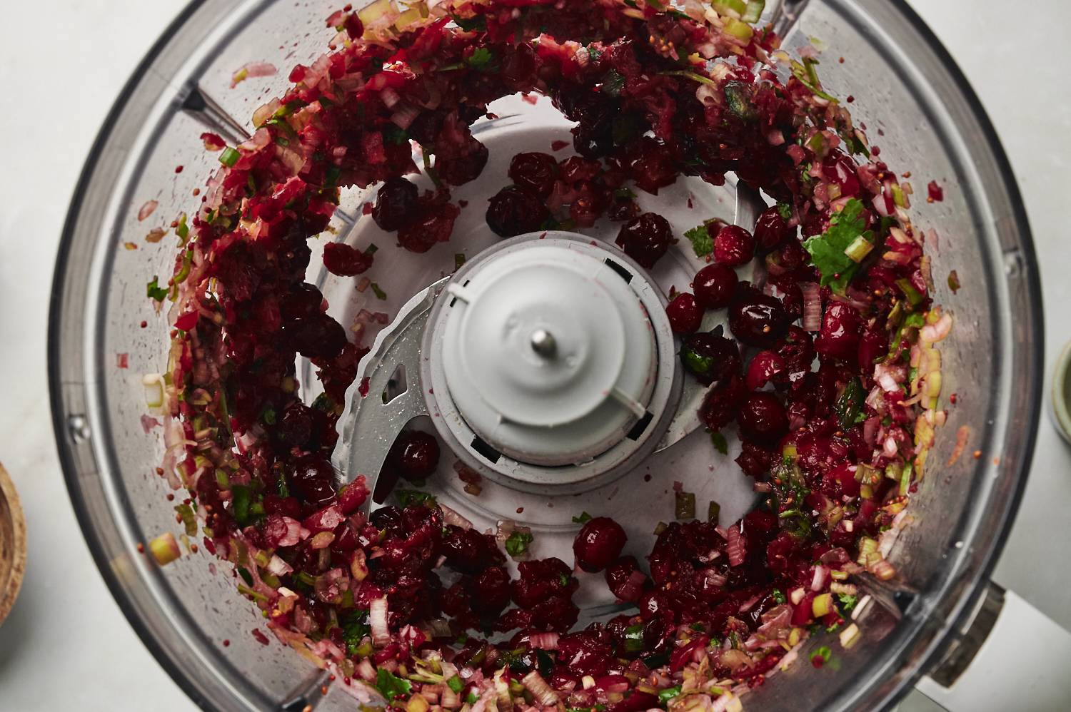 Cranberries in a food processor being chopped.