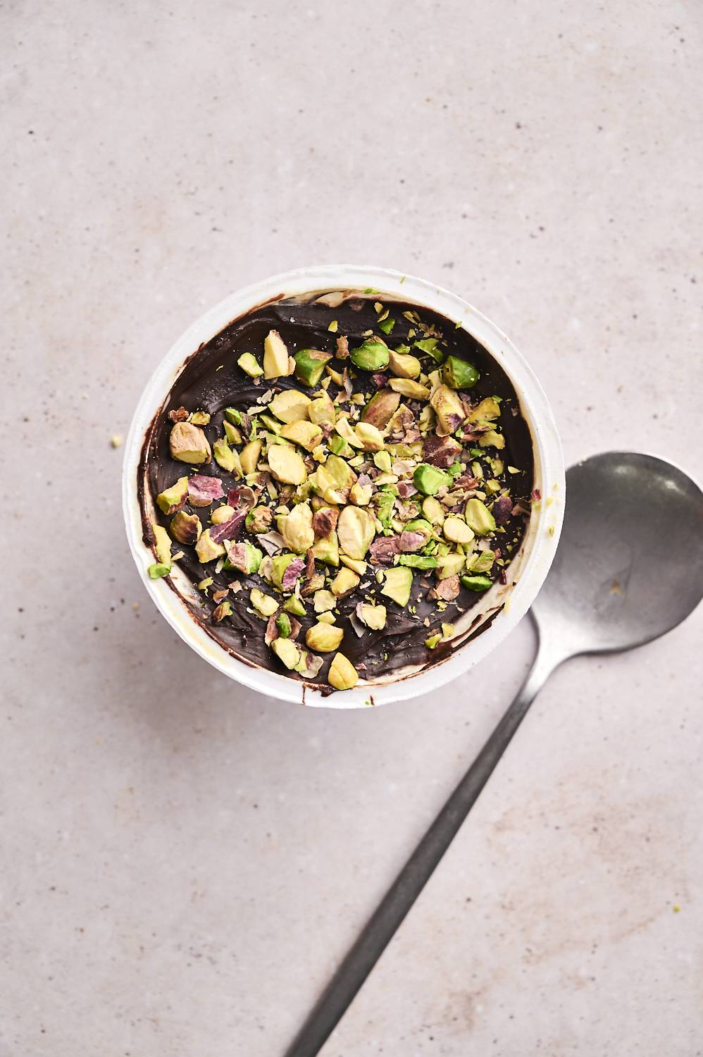 A close-up of a finished Dubai chocolate yogurt cup, showing the nut and date filling.