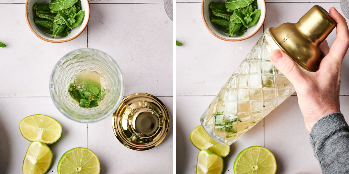 A cocktail shaker held over mint leaves and lime halves, showcasing the mix of ingredients for a refreshing drink preparation.