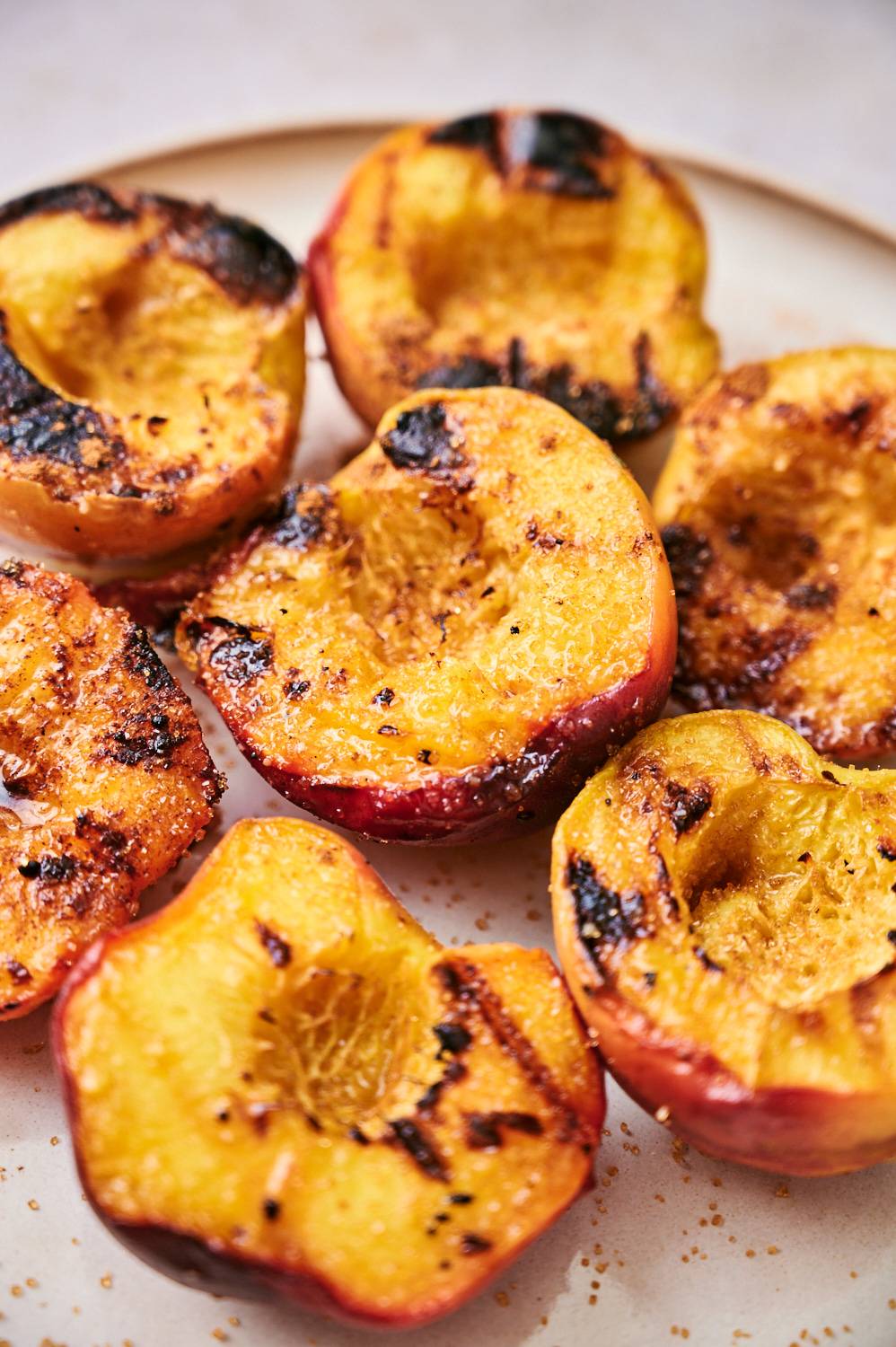 Plate with grilled peaches sprinkled with cinnamon and brown sugar.