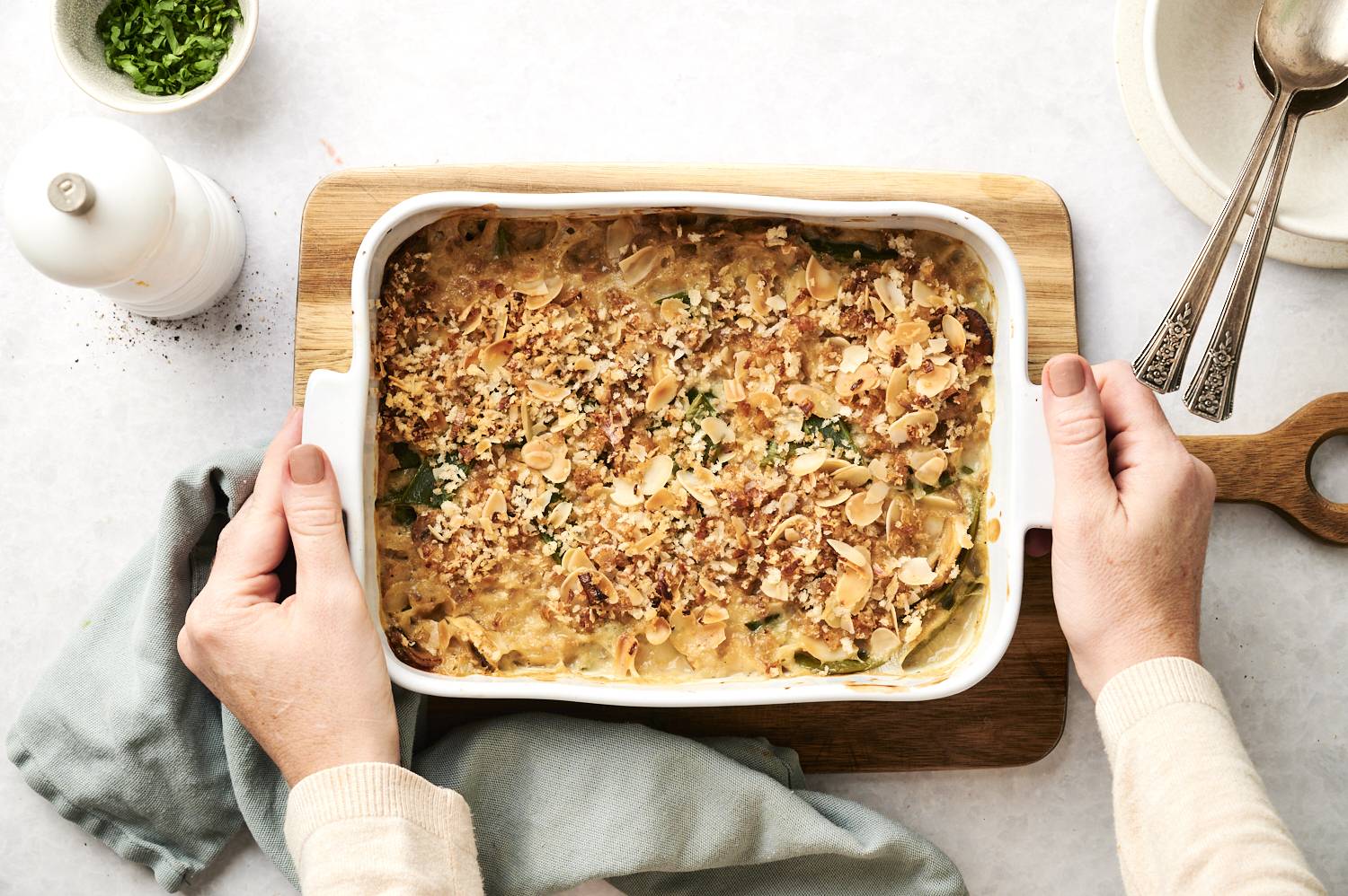 Hands holding a pan of green bean casserole.