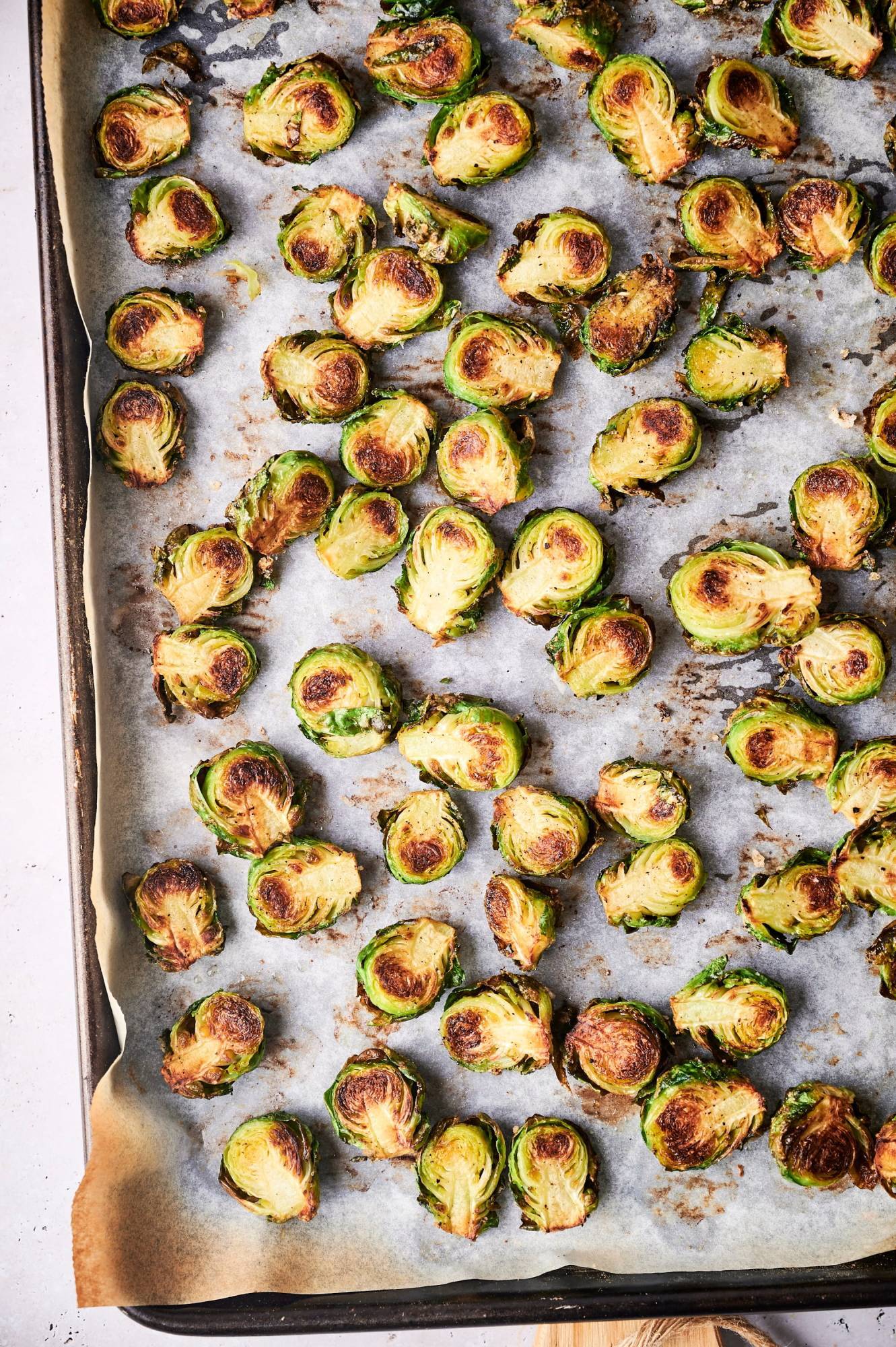 Crispy roasted brussels sprouts with browned edges on a baking sheet covered in parchment paper.