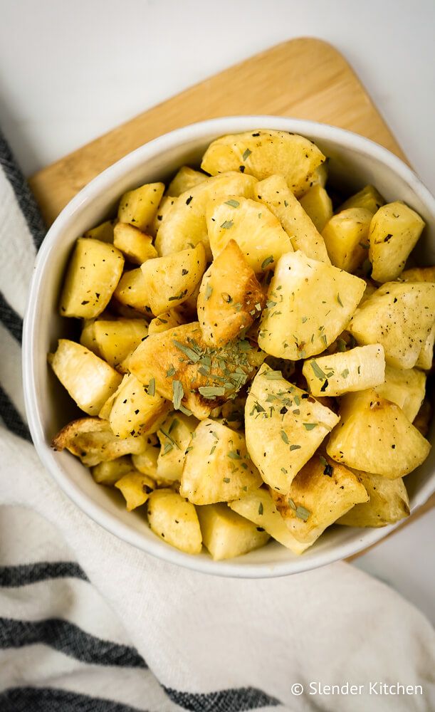Parsnips that are roasted in olive oil, salt, pepper, and spices in a bowl with a striped napkin.