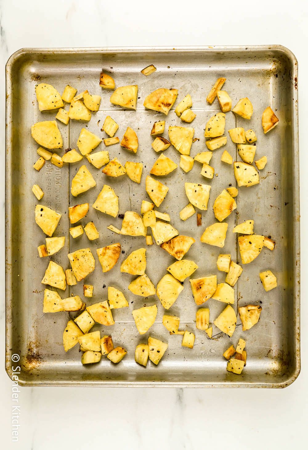 Roasting parsnips on a baking sheet with olive oil and spices.