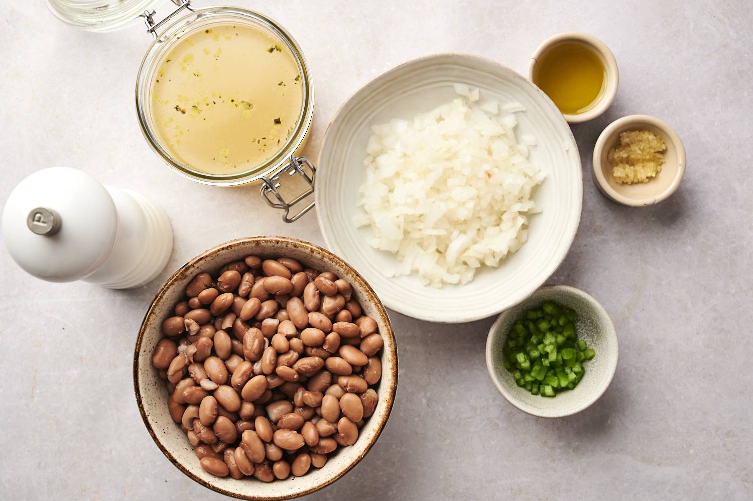 Ingredients for refried beans are laid out, including pinto beans, diced onions, minced garlic, jalapeños, olive oil, broth, and seasoning.