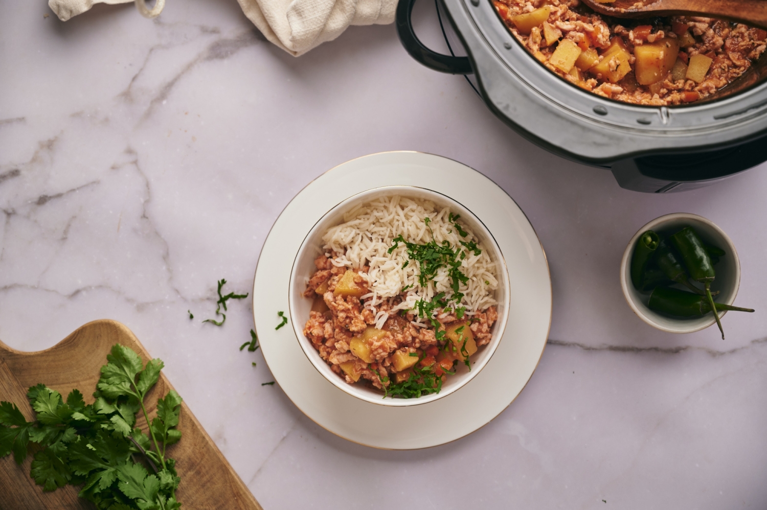Bowl with slow cooker picadillo served with white rice and cilantro.