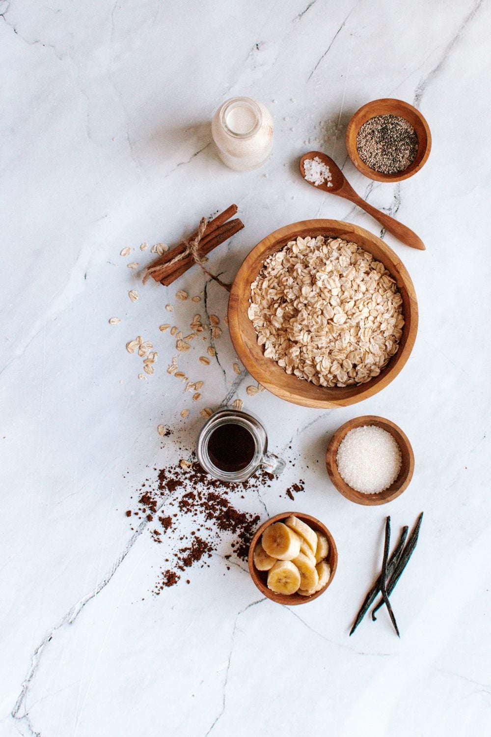 Ingredients for overnight oatmeal with coffee, vanilla, cinnamon, and almond butter.