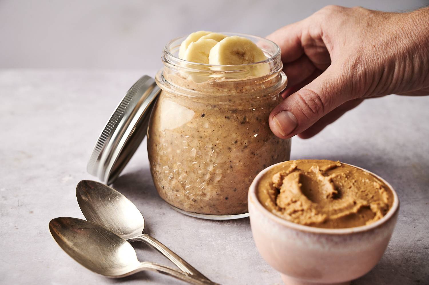 A side shot of a finished jar of peanut butter banana overnight oatmeal.