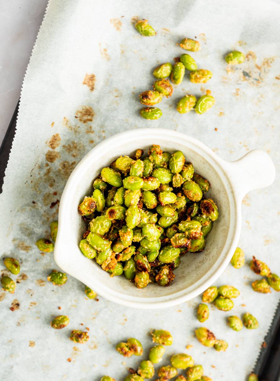Crispy roasted edamame with garlic and Parmesan cheese in a white bowl.