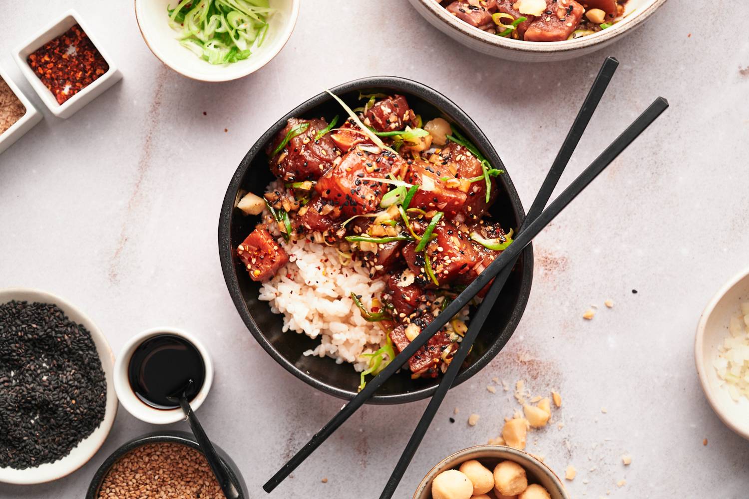 Ahi tuna poke with raw tuna, onion, soy sauce, sesame seeds, green onions, and seaweed in a bowl.