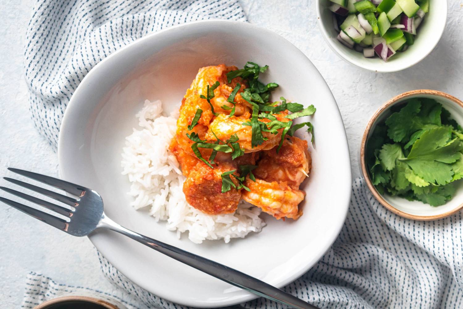 Camarones a la diabla served with shrimp cooked in a spicy red chile sauce with white rice, cilantro, and limes.