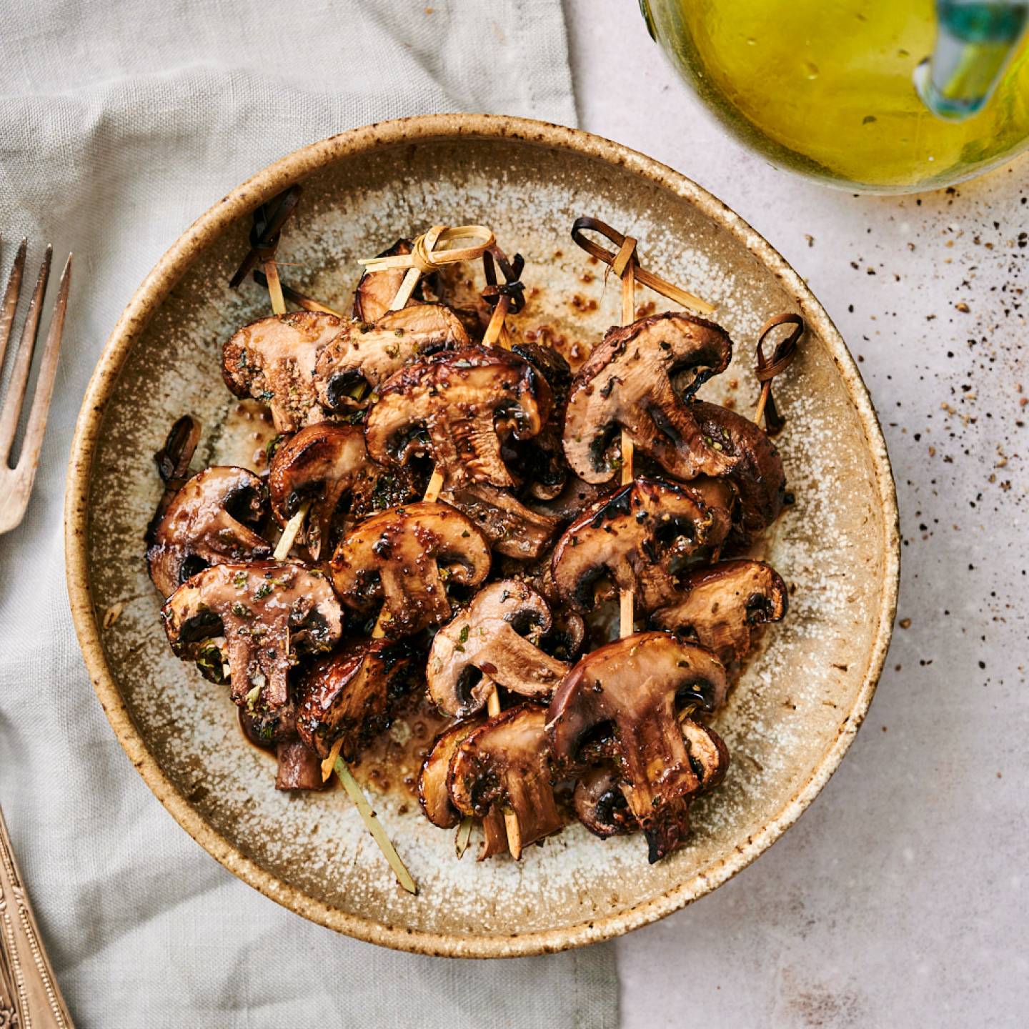 Grilled mushrooms with balsamic vinegar, olive oil, and garlic powder on a plate.