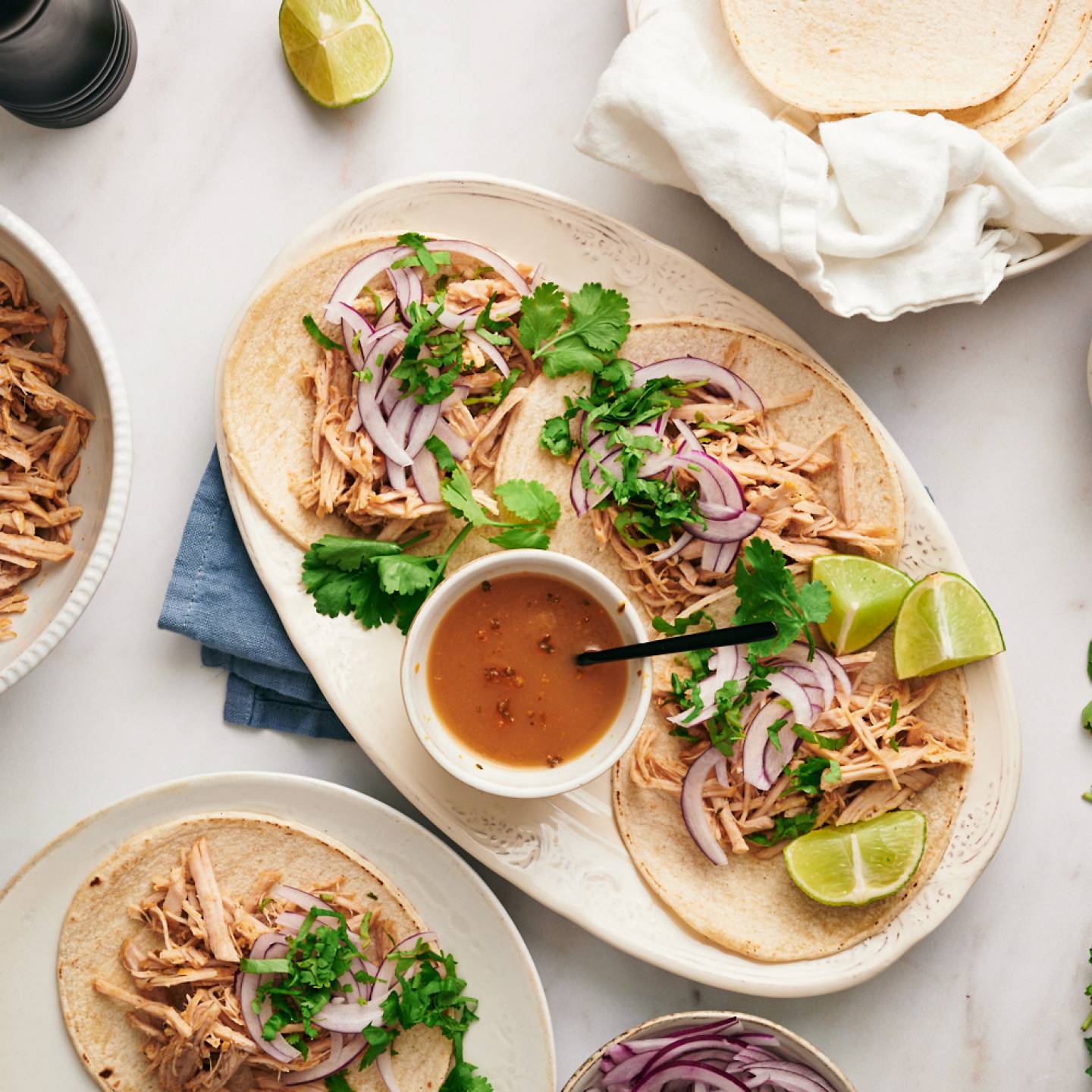 Healthy carnitas tacos with shredded pork, cilantro, and onion served in corn tortillas.