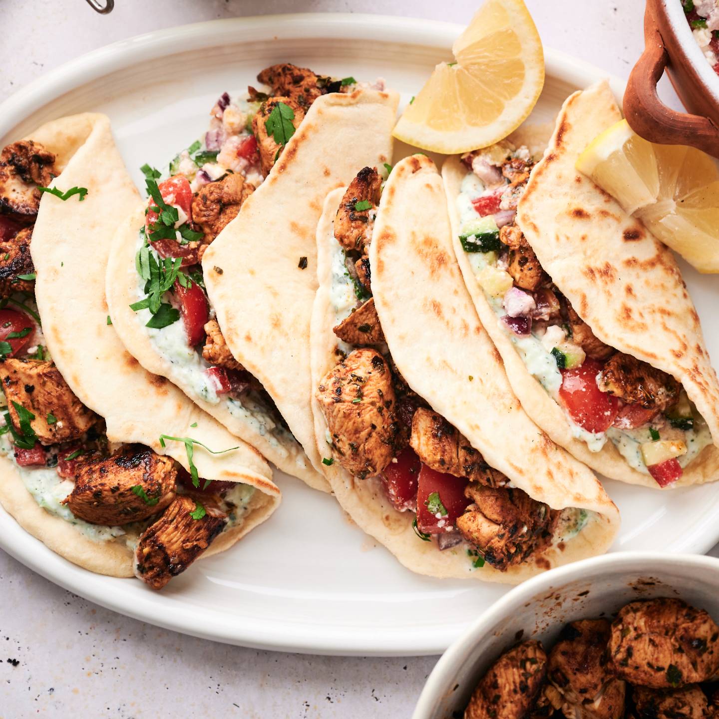 Mediterranean chicken tacos with cucumber tomato salsa, feta cheese, olives, and tzaztziki.