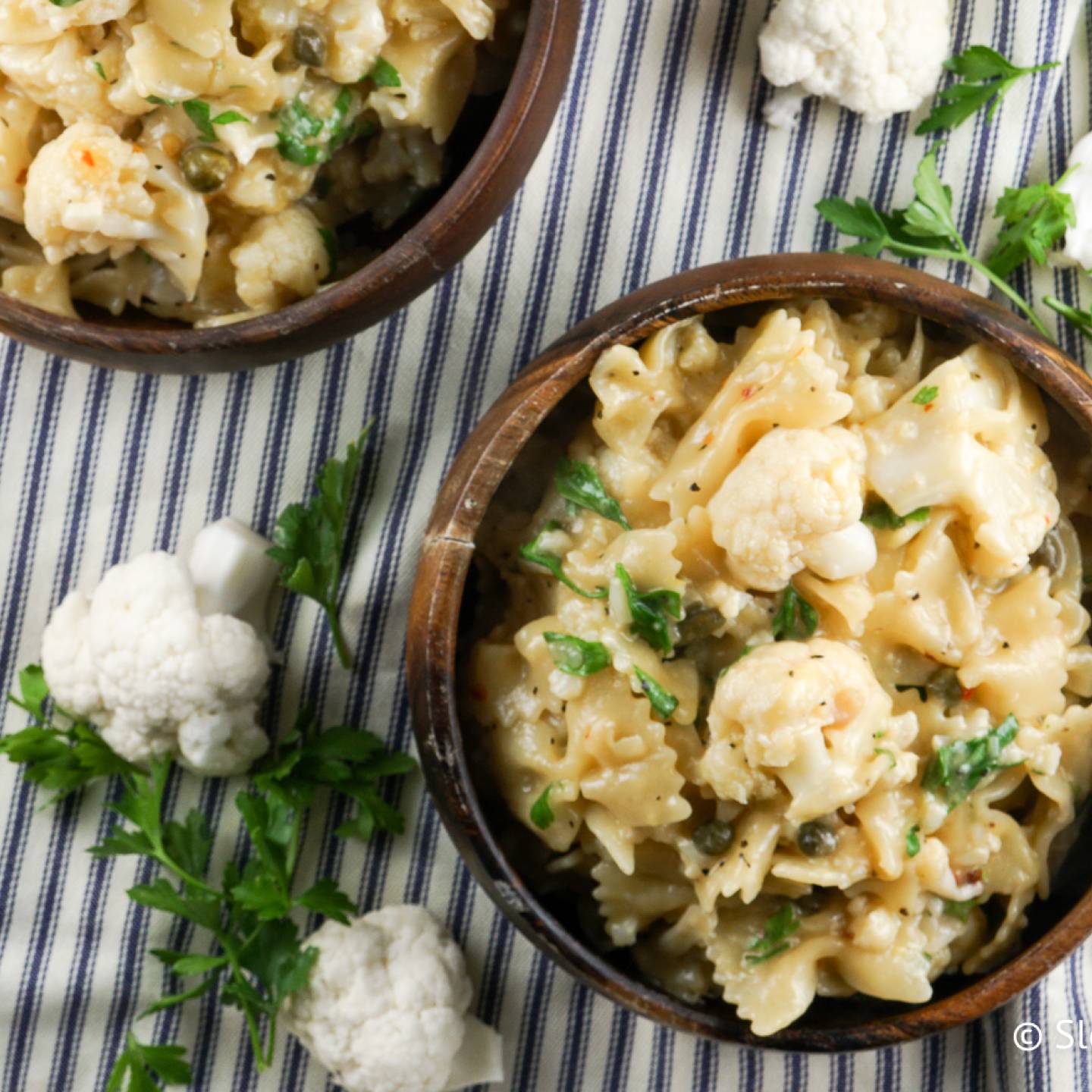 Cauliflower piccata pasta with capers, garlic, lemon, butter, and parsley in a bowl.