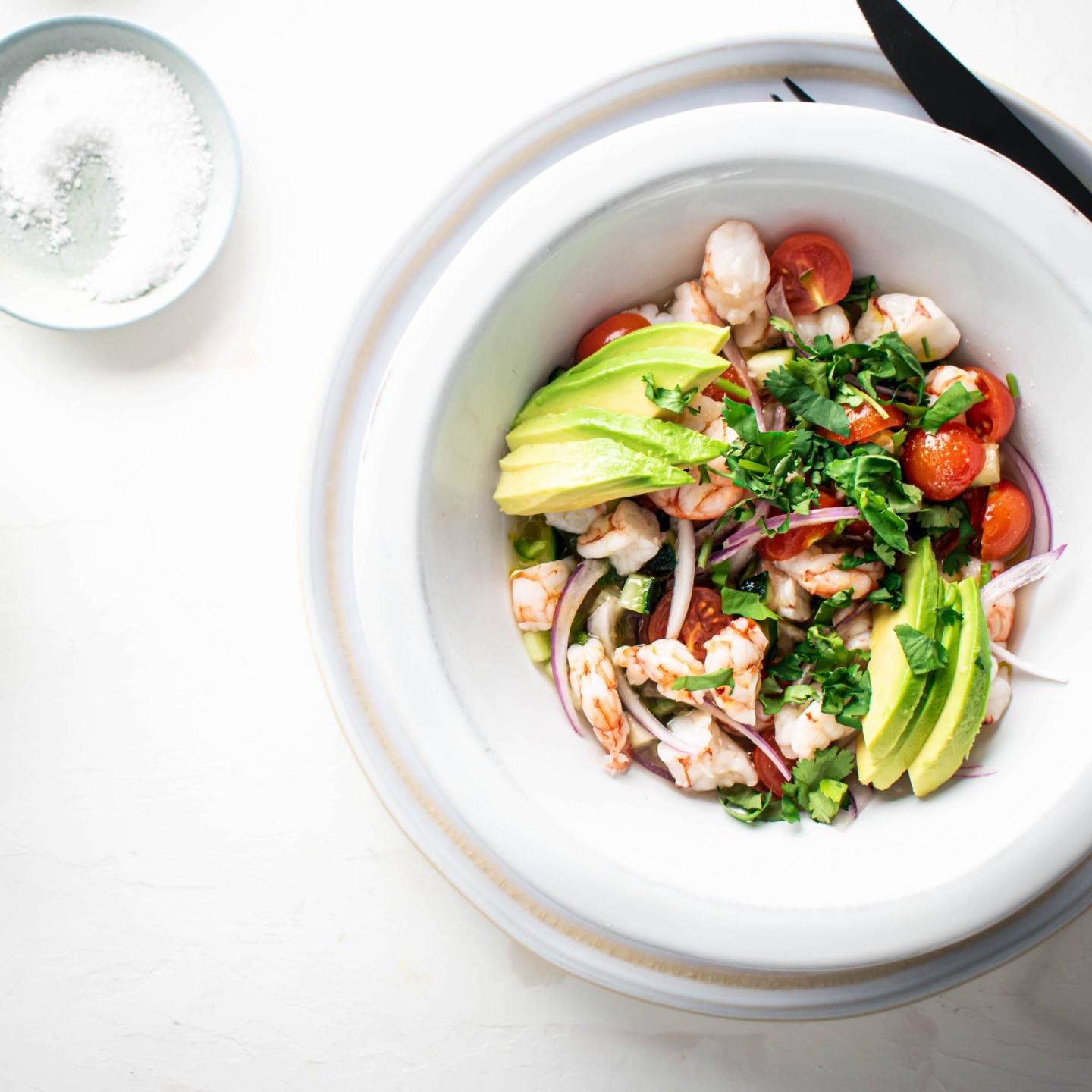 Shrimp Ceviche cured in lime juice with avocado, tomatoes, cucumbers, and red onion.
