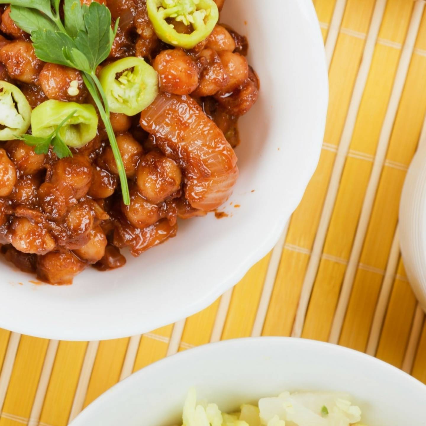 Slow cooker sweet and spicy chickpeas in a bowl with sliced jalapenos on top.