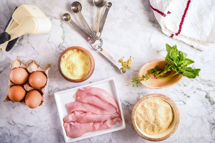 Ingredients for Parmesan crusted chicken on a marble surface.