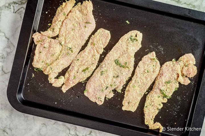 Parmesan crusted chicken tenders on a baking sheet.