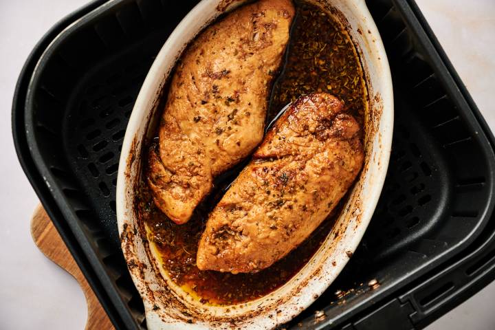 Two marinated turkey tenderloins in an air fryer.