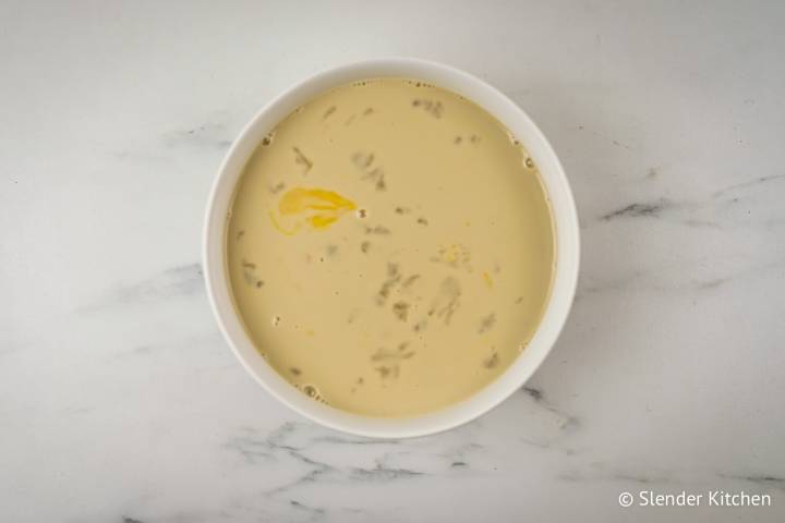 Almond milk, eggs, maple syrup, and vanilla extract in a bowl.