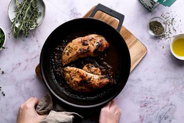 Two turkey tenderloins in a cast iron skillet.