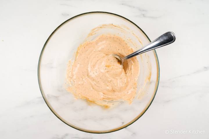 Buffalo dressing with Greek yogurt, mayonnaise, spices, and buffalo sauce in a bowl.