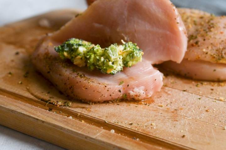 Chicken breasts being stuffed with cheddar and broccoli.
