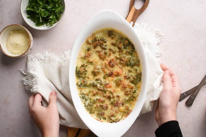 Creamed kale with a crispy parmesan topping in a baking dish.