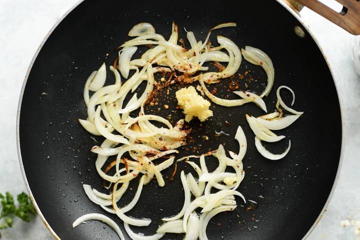 Sliced onions and garlic in a skillet with olive oil.