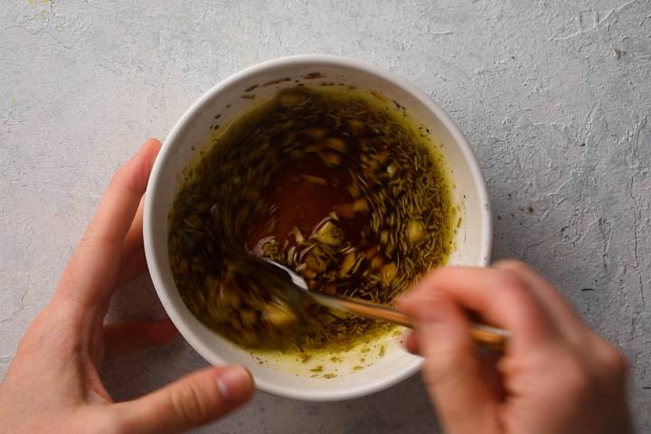Lemon, soy sauce, olive oil, garlic, and Italian seasoning mixed in a bowl.