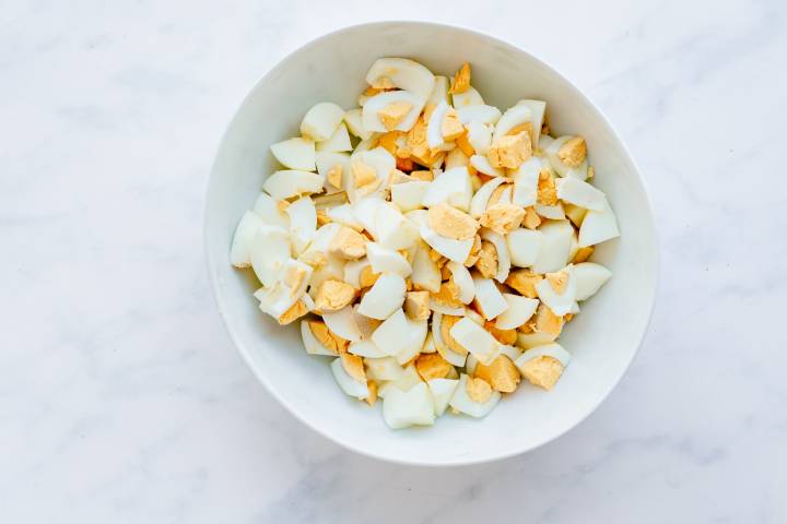 Hard boiled eggs chopped in a bowl.