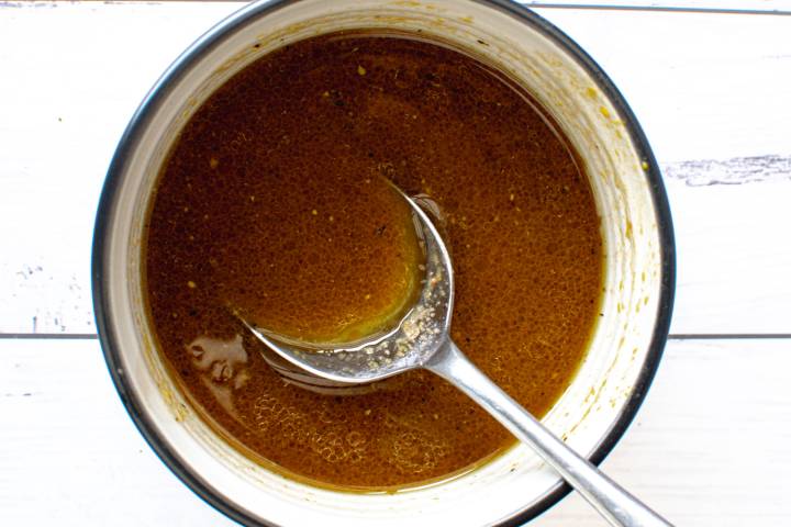 Honey mustard sauce in a bowl with a spoon.