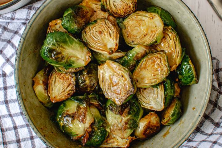 Roasted honey mustard Brussels sprouts in a bowl with a checked napkin.