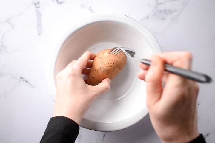 Sweet potato being pierced with a fork. 