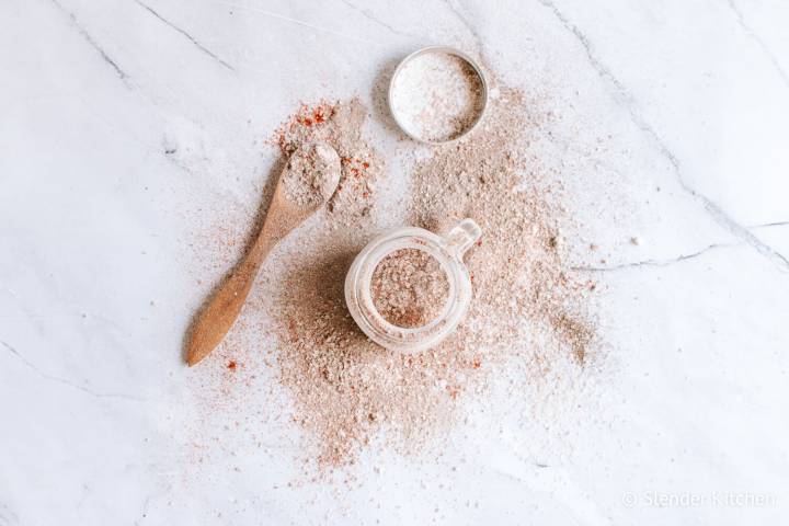 Miced homemade seasoned salt in a glass jar with a spoon and lid. 