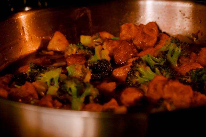 Sesame chicken and broccoli cooking in a pan in the oven.