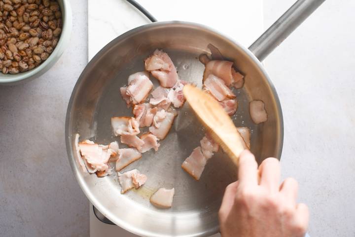 Bacon cooking in a hot skillet.